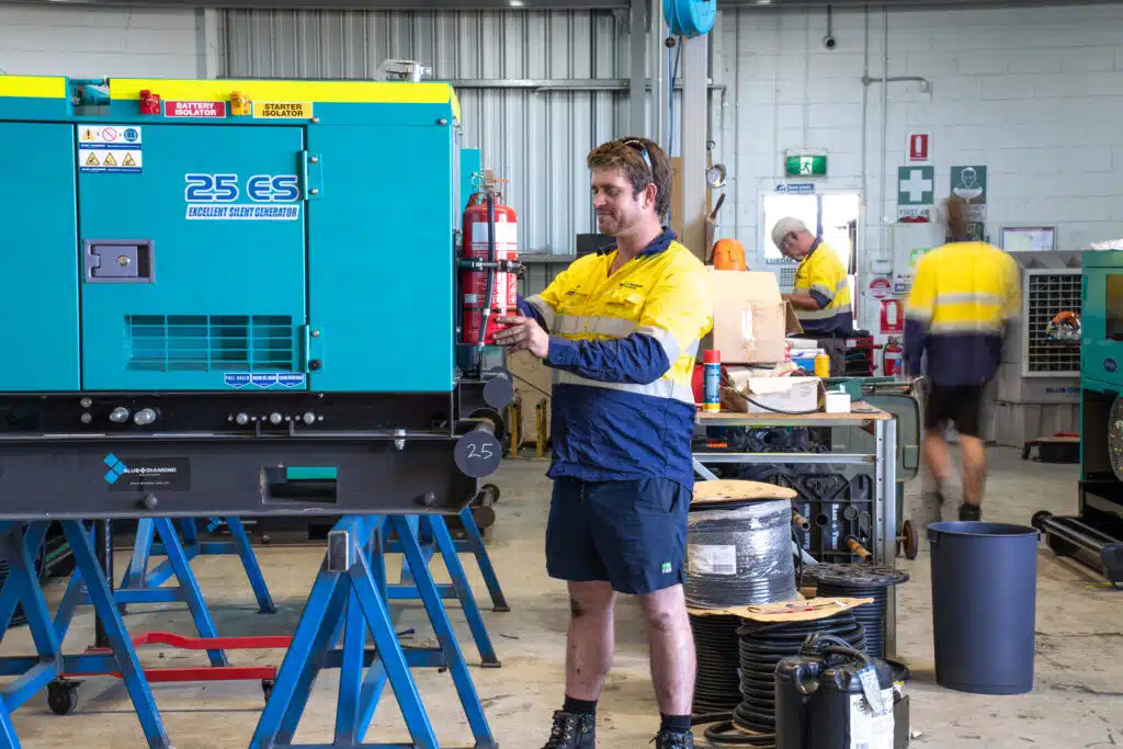 Blue Diamond Machinery warehouse worker performing a service on a diesel generator.