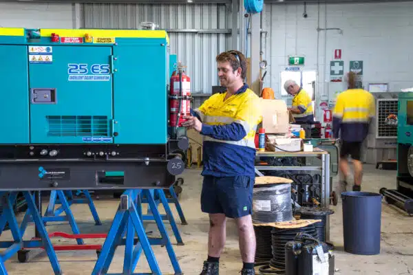 Blue Diamond Machinery warehouse worker performing a service on a diesel generator.